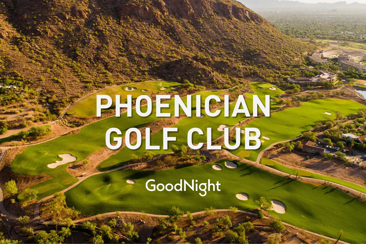 A lush green golf course with fairways stretching into the distance, bordered by mountains. The early morning or late afternoon light casts a gentle glow, enhancing the course’s beauty. The tranquil mood suggests both relaxation and the thrill of early tee times or evening events.