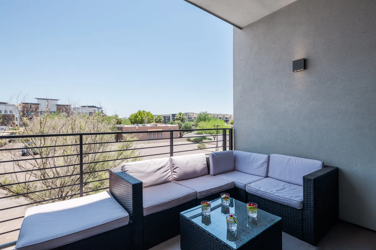 A serene outdoor seating area with a glass table overlooks the surrounding landscape, ideal for relaxing, socializing, or unwinding after a day of activities.