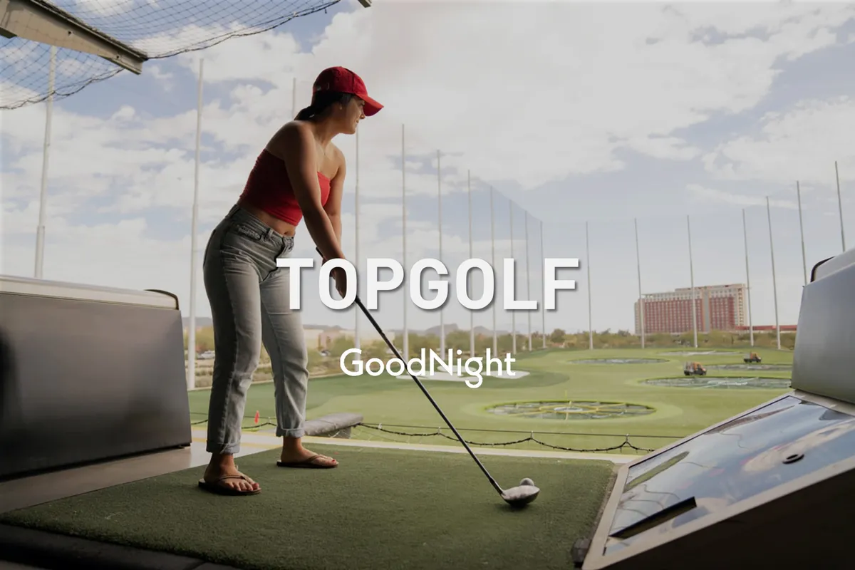 An energetic exterior shot of a golfer preparing to swing at a driving range, with friends and the skyline in the background. The image conveys excitement, fun, and friendly competition in an outdoor setting.